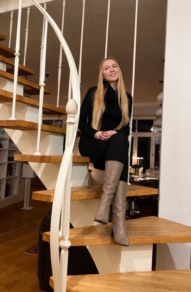 Ieva Melāne sēž uz koka kāpnēm